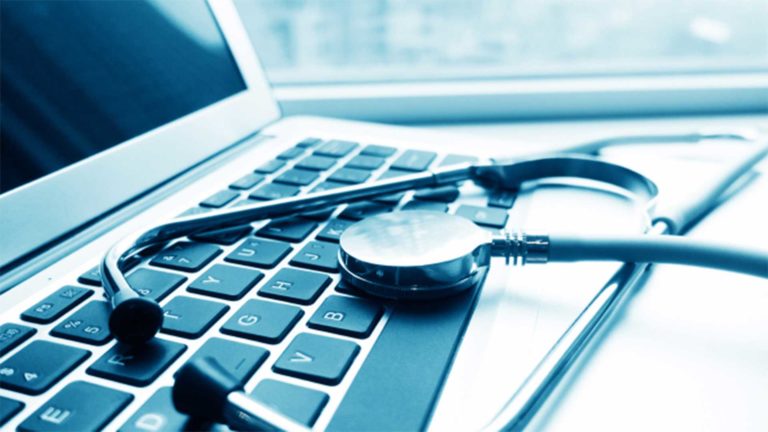 Stethoscope laying on top of a laptop