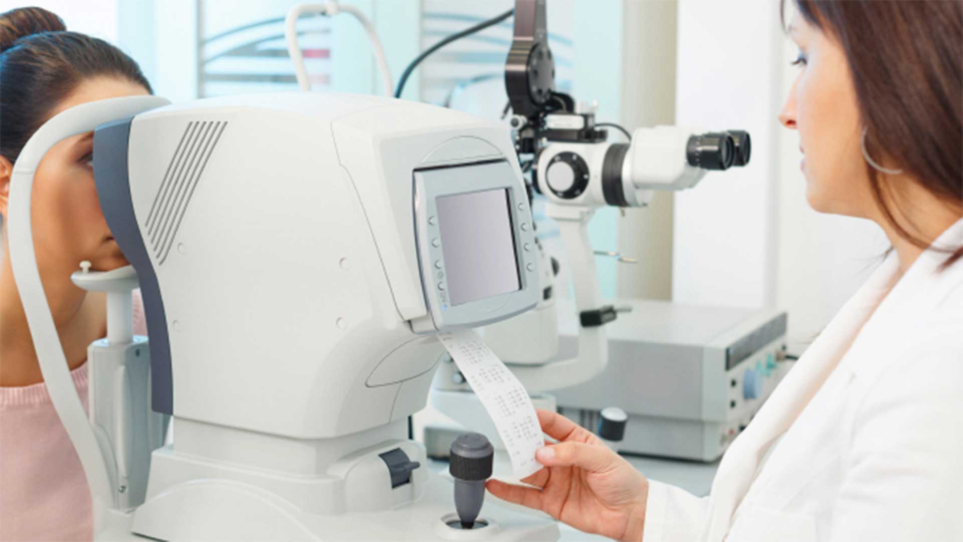 Doctor using machine to check eyes of patient