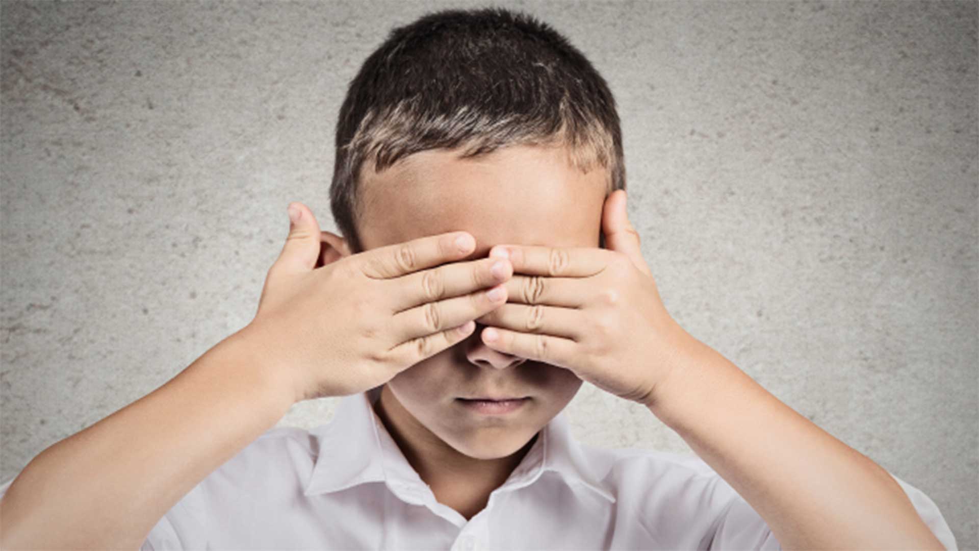 Child hiding his eyes with his hands