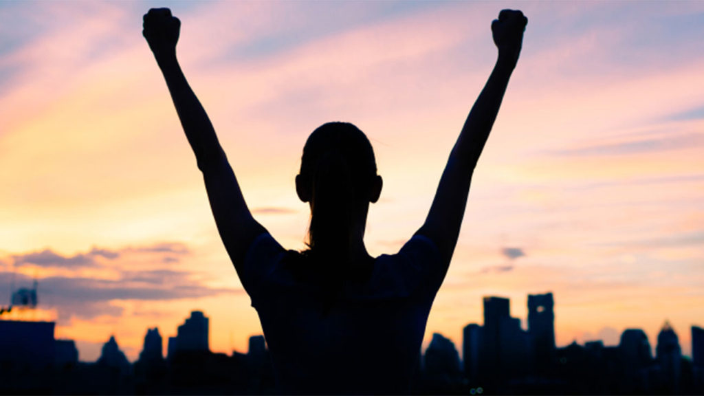 Woman with arms stretched out to the sky