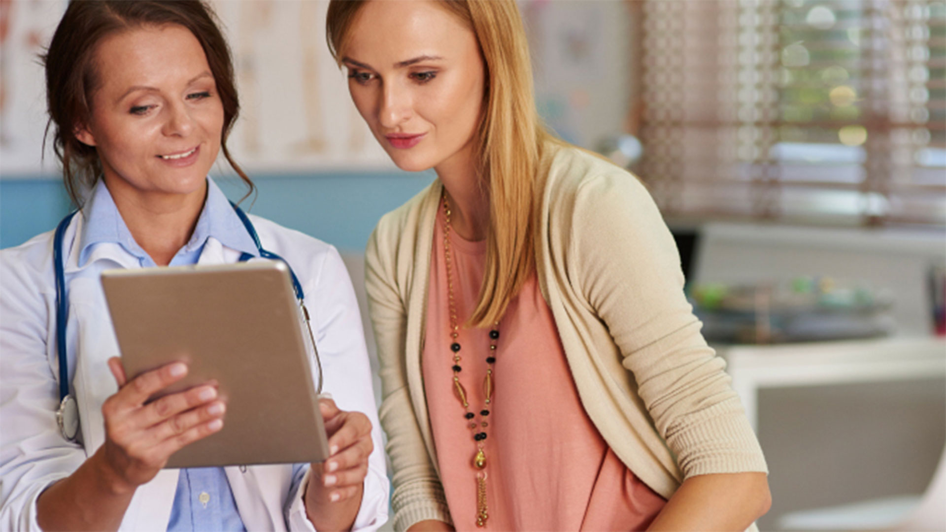 Woman doctor and patient looking at iPad