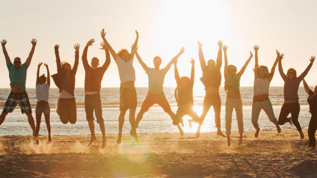 Group of people jumping up with hands raised to the sky