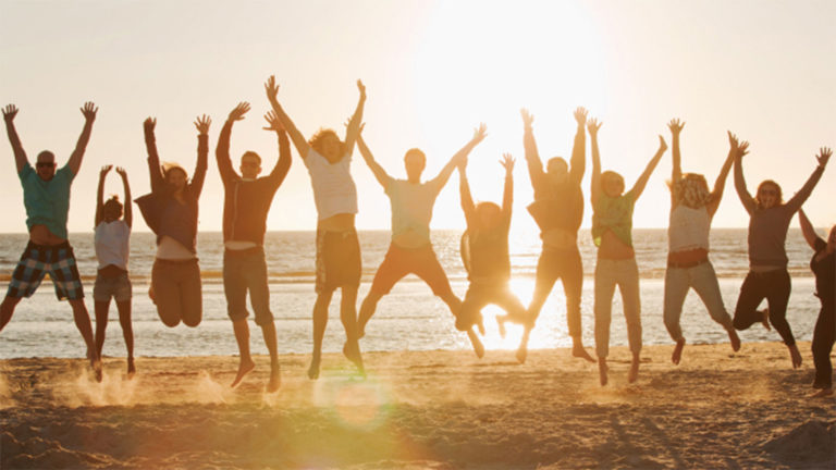 Group of people jumping up with hands raised to the sky